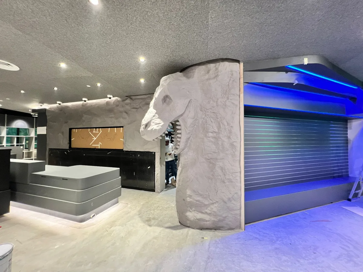 Sculpted dinosaur-skull rock feature wall at a Mandai Zoo retail fit-out